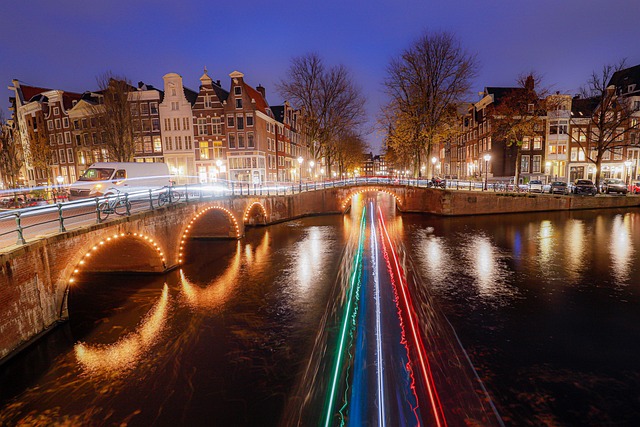 Twilight view of Amsterdam's iconic canal houses, a prime location for finding central hotels and hostels.