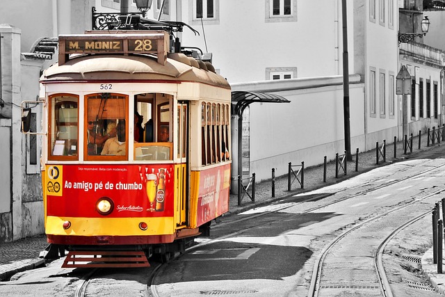 The iconic yellow Tram 28 climbing a hill in Lisbon, a top destination for travelers looking for budget hotels in Portugal.